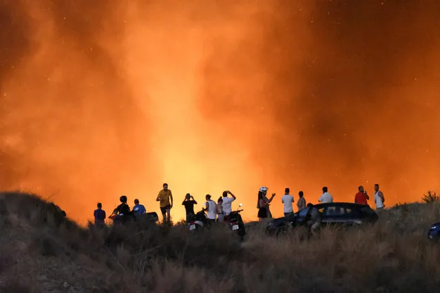 People look on a forest fire in the area Altos de Marbella, near of AP-7 highway in the town of Marbella, Costa del Sol, southern Spain, 22 August 2019 (issued 23 August 2019). Residents of some 40 houses had to be evacuated due to forest fire that was stabilized around last midnight. (Photo by /EPA/EFE/APZ)