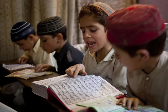 Kashmiri Muslim children recite verses from the holy Quran at a Muslim religious school, during the holy month of Ramadan in Srinagar, Indian controlled Kashmir, Thursday, July 2, 2015. Muslims across the world are observing the holy fasting month of Ramadan, where they refrain from eating, drinking and smoking from dawn to dusk. (Photo by Dar Yasin/AP Photo)