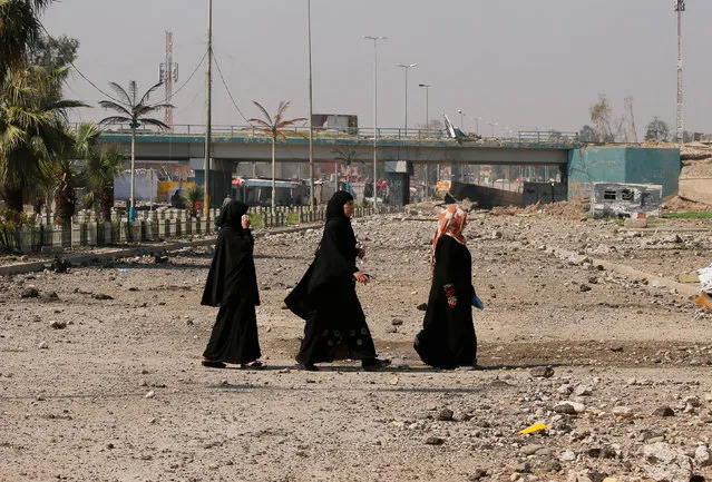 Iraqi women walk along a street in an area controlled by Iraqi forces in Western Mosul, Iraq March 30, 2017. (Photo by Youssef Boudlal/Reuters)