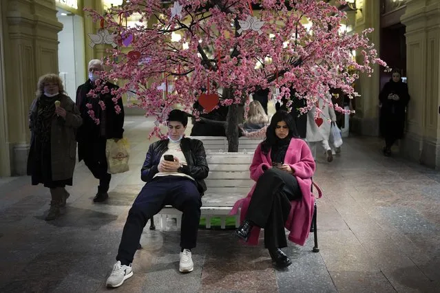 Visitors rest in the GUM department store in Moscow, Russia, Monday, February 14, 2022. (Photo by Alexander Zemlianichenko/AP Photo)