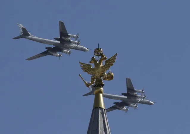 Russian Tu-95MS strategic bombers fly in formation during the Victory Day parade, marking the 71st anniversary of the victory over Nazi Germany in World War Two, above the two-headed eagle statue at the top of the State Historical Museum in Moscow, Russia, May 9, 2016. (Photo by Maxim Shemetov/Reuters)