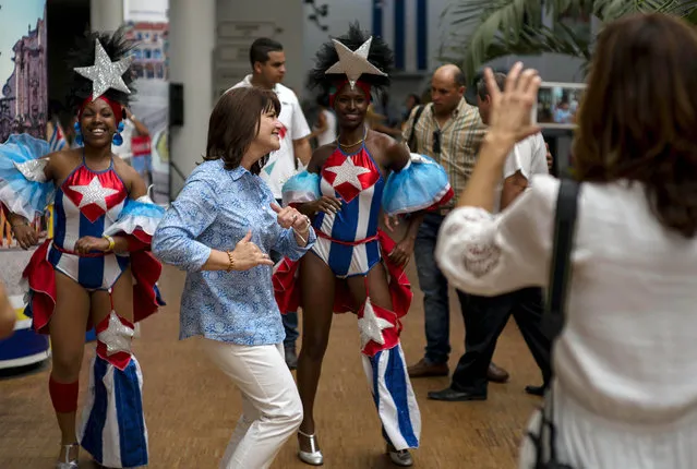 An unidentified passenger of Carnival's Adonia cruise ship dances with a couple of Cuban entertainers, as locals welcome the cruise passengers, who came from Miami, to Havana, Cuba, Monday, May 2, 2016. The Adonia's arrival is the first step toward a future in which thousands of ships a year could cross the Florida Straits, long closed to most U.S.-Cuba traffic due to tensions that once brought the world to the brink of nuclear war. (Photo by Ramon Espinosa/AP Photo)