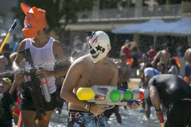 Participants wear masks during a water fight in Tel Aviv, July 10, 2015. (Photo by Baz Ratner/Reuters)