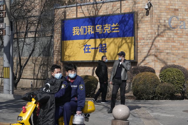 A sign outside the Canadian Embassy showing the Ukraine flag reads “We stand together with Ukraine” on Thursday, March 3, 2022, in Beijing. China on Thursday denounced a report that it asked Russia to delay invading Ukraine until after the Beijing Winter Olympics as “fake news” and a “very despicable” attempt to divert attention and shift blame over the conflict. (Photo by Ng Han Guan/AP Photo)