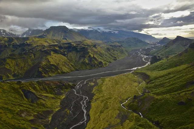 “Clouds Over Eyjafjallajokull”. On a cloudy day we traveled to the west end of the Vatnajokull Glacier in Iceland, when the clouds opened it showed us this amazing valley with Eyjafjallajokull and Katla standing over a river floor layered with black ash, sand and lava from years of furious eruptions and flooding. Photo location:  Iceland. (Photo and caption by Adam Henning/National Geographic Photo Contest)