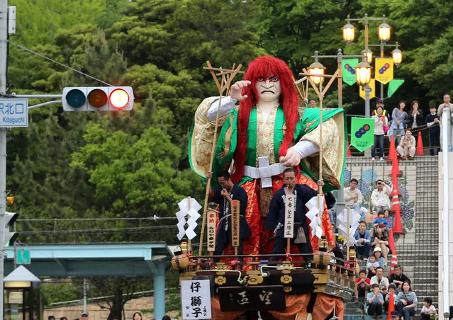 Festival goers pull huge paper doll of historical Japanese figure named Ko-shishi on the carts during the Mikuini annual festival on May 20, 2014 in Sakai, Japan. The annual festival takes place from May 19-21 and is attended by thousands of visitors. During the festival people dressed in traditional Japanese costumes pull carts carrying 6 meter high dolls of Japanese historical figures through the narrow streets. The origins of the festival are unclear but its history can be traced back more than 250 years. (Photo by Buddhika Weerasinghe/Getty Images)