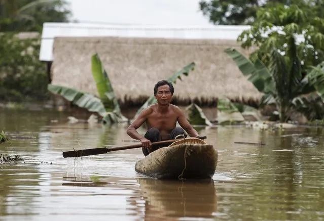 A man padles a canoe along a flooded street at a village in Kawlin township, Sagaing division, Myanmar, July 21, 2015. (Photo by Soe Zeya Tun/Reuters)