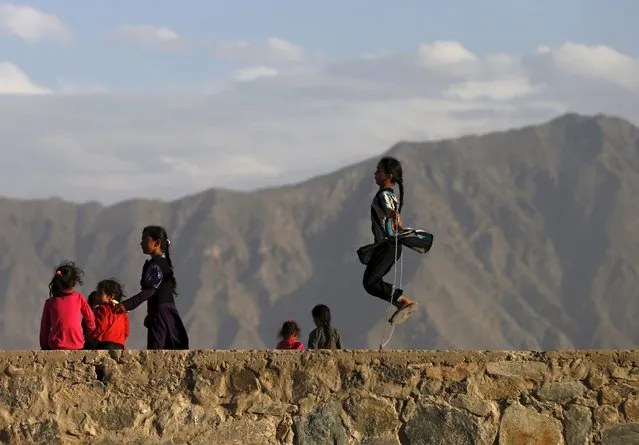 An Afghan girl (R) jumps rope on a hilltop in Kabul, Afghanistan May 18, 2015. (Photo by Mohammad Ismail/Reuters)
