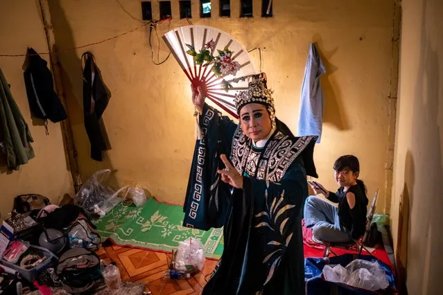 A performer poses for photos before going onstage at a show of hat tuong (local word from the North) or hat boi (local word from the South), a traditional form of Vietnamese theatre influenced by Chinese opera, at a makeshift stage in a temple on March 19, 2022 in Ho Chi Minh City, Vietnam. (Photo by Linh Pham/Getty Images)