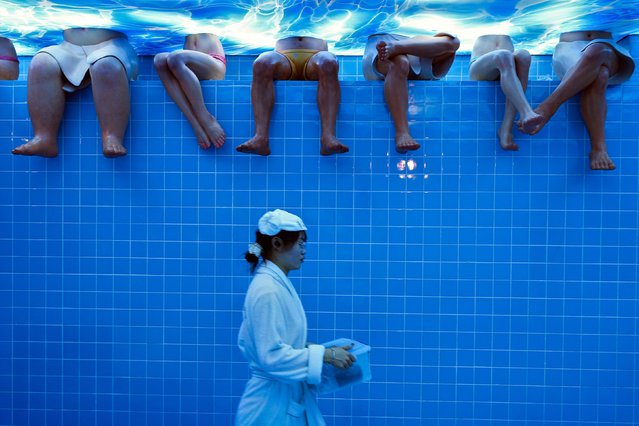 A waitress wearing bathrobe walks by mannequins at a restaurant setup as a bathing center at an old Beijing's hutong alley inside a shopping mall in Beijing, Sunday, August 11, 2024. (Photo by Andy Wong/AP Photo)