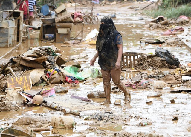 A resident walks amongst debris of destroyed belongings next to her house at a village in Manila on July 25, 2024, a day after heavy rains fuelled by Typhoon Gaemi and the seasonal monsoon lashed Manila and surrounding regions in recent days. (Photo by Ted Aljibe/AFP Photo)