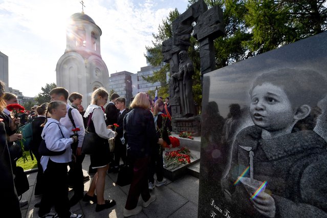 People attend a ceremony to commemorate the 20th anniversary of the 2004 hostage-taking at the Beslan school, on the grounds of the Church of the Dormition of the Blessed Virgin Mary in Saint Petersburg on September 3, 2024. More than 330 hostages had been killed during the attack by pro-Chechen rebels, 186 of them were children, and about 750 people were injured. (Photo by Olga Maltseva/AFP Photo)