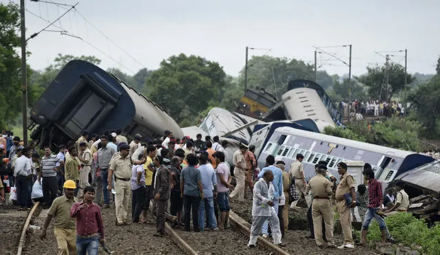 People gather at the site of a train accident near the town of Harda in Madhya Pradesh state, India, Wednesday, August 5, 2015. (Photo by AP Photo)