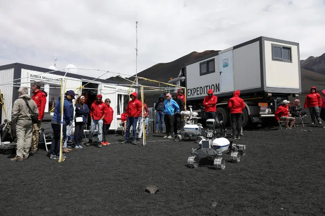 Scientists from German Aerospace Center stand in front of a robot on Mount Etna, Italy on July 4, 2017. (Photo by Antonio Parrinello/Reuters)