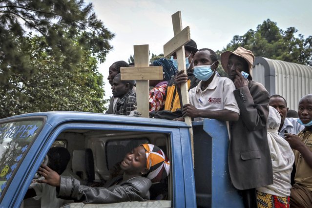 Relatives ride in the back of a truck with the coffins of villagers who were killed by suspected rebels as they retreated from Saturday's attack on the Lhubiriha Secondary School, outside the mortuary of the hospital in Bwera, Uganda Sunday, June 18, 2023. Ugandan authorities have recovered the bodies of 41 people including 38 students who were burned, shot or hacked to death after suspected rebels attacked the school in Mpondwe near the border with Congo, according to the local mayor. (Photo by Hajarah Nalwadda/AP Photo)