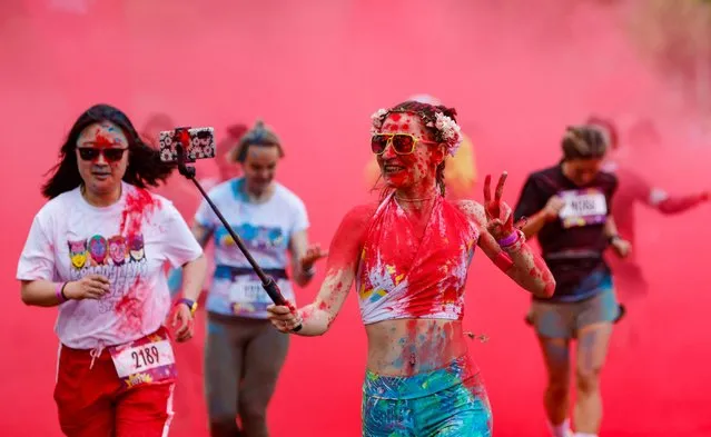 Participants run through coloured powder during the Colour Run race in Moscow, Russia on June 5, 2022. (Photo by Maxim Shemetov/Reuters)