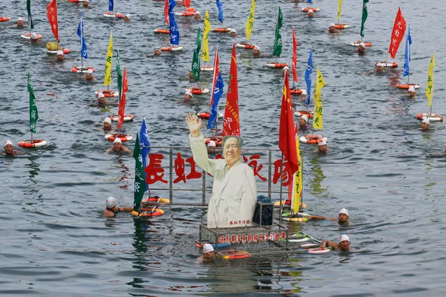 People swim with a portrait of late Chinese Chairman Mao Zedong in Han River, a large branch of the Yangtze River, as hundreds of people take part in celebration of the upcoming 51st anniversary of Chairman Mao swimming in the Yangtze River on July 16, 1966 in Xiangyang, Hubei province, China, July 15, 2017. (Photo by Reuters/China Stringer Network)