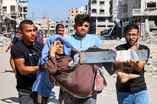 Men carry injured woman to be evacuated in the Jabalia camp for Palestinian refugees in the northern Gaza Strip on October 9, 2024 amid the ongoing war in the Palestinian territory between Israel and Hamas. (Photo by Omar Al-Qattaa/AFP Photo)