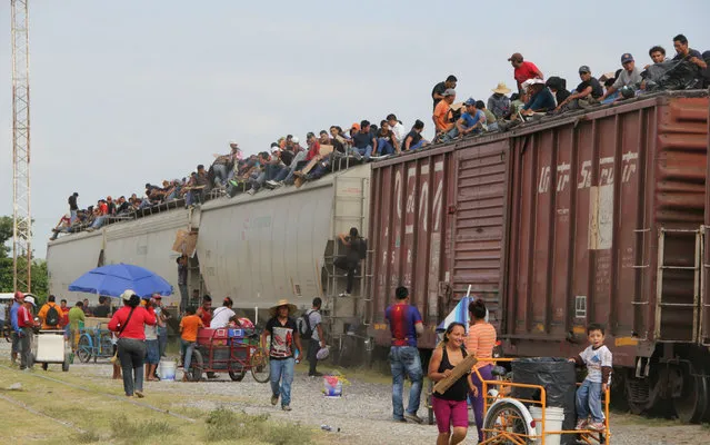 Central American immigrants get on the so-called La Bestia (The Beast) cargo train, in an attempt to reach the Mexico-US border, in Arriaga, Chiapas state, Mexico on July 16, 2014. (Photo by Elizabeth Ruiz/AFP Photo)