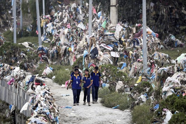 Students walk past the debris, mostly plastic waste dumped into the river by the people, as the flood water recedes from the bank of Bagmati river following the deadly flood due to heavy rains, in Kathmandu, Nepal, on October 2, 2024. (Photo by Navesh Chitrakar/Reuters)