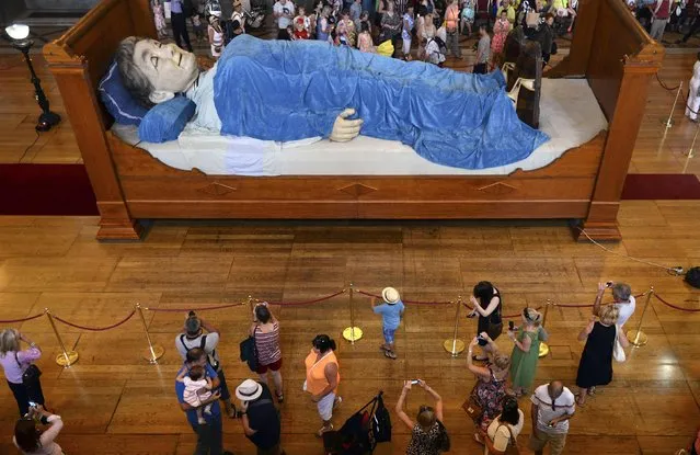 A giant puppet of a grandmother lies on a bed inside St. George's Hall in Liverpool, England, on Jule 23, 2014. The grandmother is one of two giant models made for a World War I commemorative event. (Photo by Nigel Roddis/Reuters)