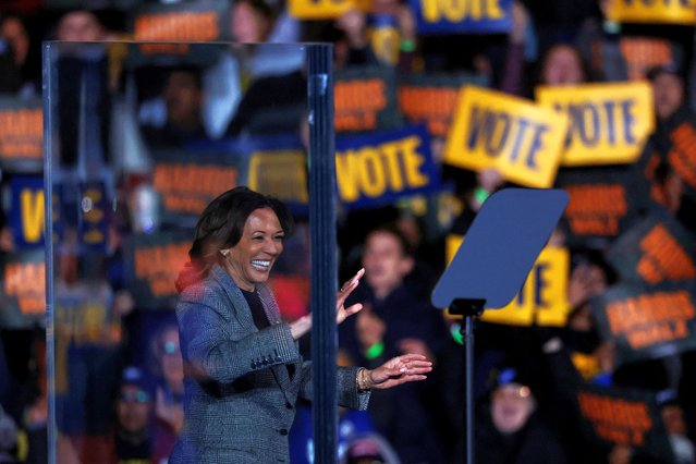 Democratic presidential nominee U.S. Vice President Kamala Harris applauds from behind a safety glass during a campaign rally and concert in Ann Arbor, Michigan, U.S. October 28, 2024. (Photo by Shannon Stapleton/Reuters)