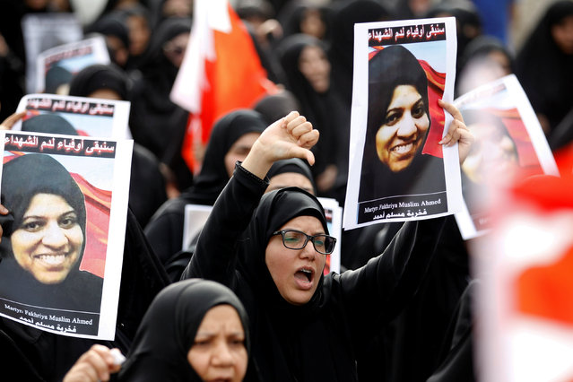 A mourner shouts anti-government slogans as she holds photo of Fakhria Muslim, victim of a bomb blast, during her funeral procession in the village of Sitra, south of Manama, Bahrain, July 2, 2016. Muslim died after being hit by shrapnel from a bomb blast in East Eker killing her instantly and injuring three children who were in the car with her, the Ministry of Interior said on Friday morning. (Photo by Hamad I. Mohammed/Reuters)