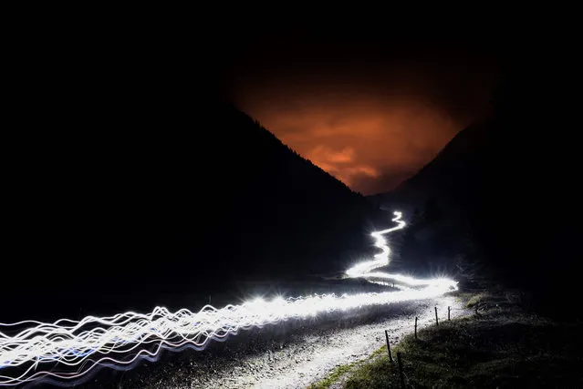In this long exposure photo, lights of ultra- trailers competing illuminate the way on the Balme path, on September 1, 2017 in Les Contamines Montjoie, during the 15 th edition of the Mount Blanc Ultra Trail (UTMB), a 170 km race around the Mont Blanc crossing France, Italy and Switzerland. (Photo by Jeff Pachoud/AFP Photo)