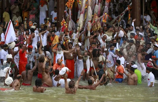 Sadhus or Hindu holy men take a dip in the Godavari river during the first Shahi Snan (grand bath) at Kumbh Mela, or Pitcher Festival in Nashik, India, August 29, 2015. (Photo by Danish Siddiqui/Reuters)