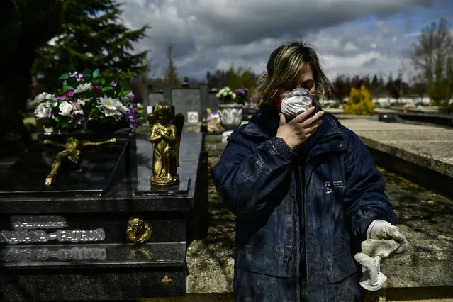 Undertaker Mari Carmen Serrador, 53 years old, protecting herself with a mask at Salvador cemetery during the coronavirus outbreak, near to Vitoria, northern Spain, Monday, March 30, 2020. (Photo by Alvaro Barrientos/AP Photo)
