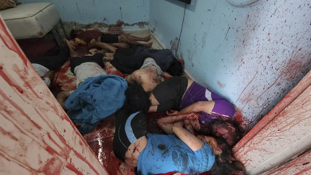 The bodies of Israeli civilians lie in pools of blood in a home where they were gathered in Kfar Azza, Israel, a kibbutz near the border with Gaza on October 7, 2023. The image was taken moments after armed Palestinian militants left the area following their attack on the kibbutz. (Photo by AP Photo/Stringer)