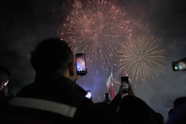 Revelers enjoy the fireworks display during the Independence Day celebrations at Mexico City's main square the Zocalo, Thursday, September 15, 2022. (Photo by Eduardo Verdugo/AP Photo)