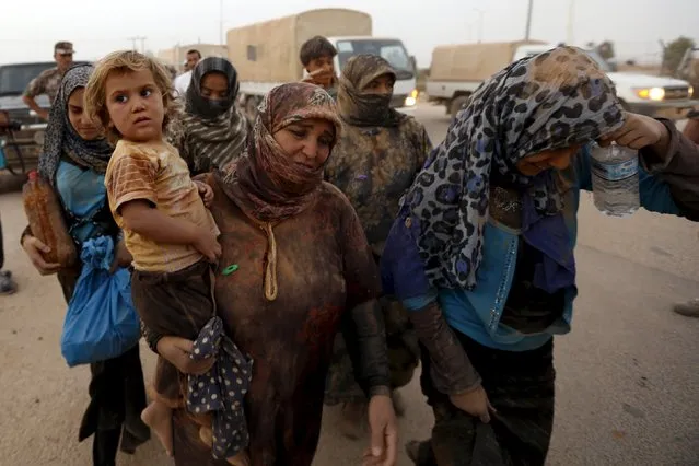Syrian refugees covered with dust arrive at the Trabeel border, after they crossed into Jordanian territory with their families, near the northeastern Jordanian border with Syria, and Iraq, near the town of Ruwaished, east of Amman September 10, 2015. (Photo by Muhammad Hamed/Reuters)