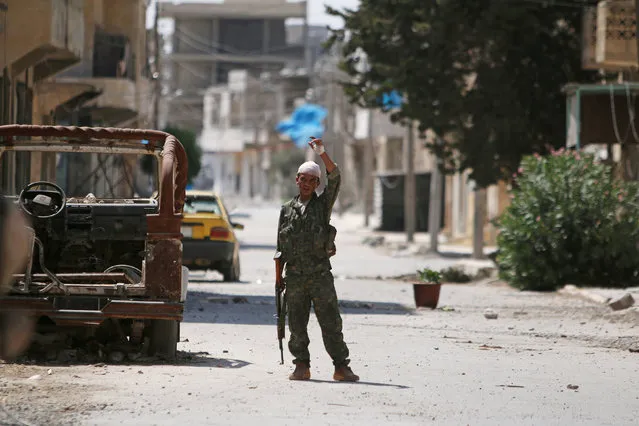 A Syria Democratic Forces (SDF) fighter gestures on a street in Manbij, in Aleppo Governorate, Syria, August 7, 2016. (Photo by Rodi Said/Reuters)