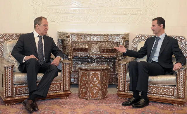 In this February 7, 2012 file photo, Syrian President Bashar Assad, right, meets with Russian Foreign Minister Sergey Lavrov in Damascus, Syria. Russia has been sending military forces into Syria in recent days, Israel's defense chief announced Thursday, as Moscow hinted at broader action to bolster President Bashar Assad's embattled army following a string of battlefield losses. (Photo by AP Photo/Pool)