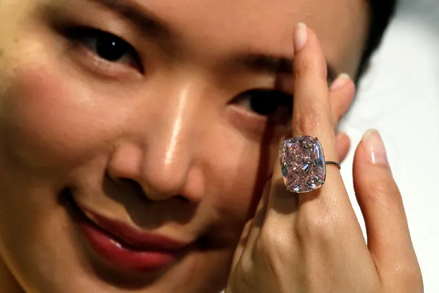 A model poses with a 37.30-carat “The Raj Pink”, the world's largest known fancy intense pink diamond expected to fetch up to $30 million in an upcoming Geneva auction, during a Sotheby's preview in Hong Kong, China October 23, 2017. (Photo by Bobby Yip/Reuters)