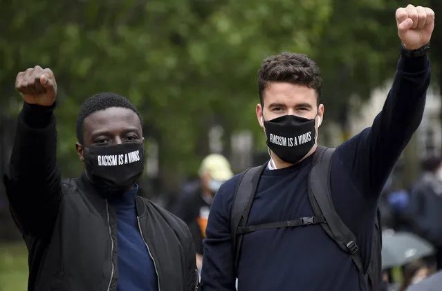 Protestors make a fist during protests in London, Friday, June 12, 2020 in response to the recent killing of George Floyd by police officers in Minneapolis, USA, that has led to protests in many countries and across the US. (Photo by Alberto Pezzali/AP Photo)