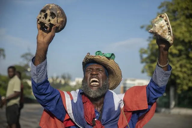 A protester holding up a skull and seashell shouts for the resignation of Haitian Prime Minister Ariel Henry in the street in the Champs de Mars area where the prime minister attended a ceremony marking the death anniversary of revolutionary leader Jean-Jacques Dessalines in Port-au-Prince, Haiti, Monday, October 17, 2022. (Photo by Joseph Odelyn/AP Photo)