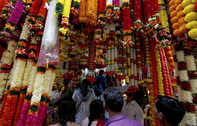 People shops for artificial flowers to decorate their homes and shops ahead of Diwali festival in Hyderabad, India, Thursday, October 20, 2022. Diwali, the the Festival of Lights will be celebrated on Oct. 24. (Photo by Mahesh Kumar A./AP Photo)