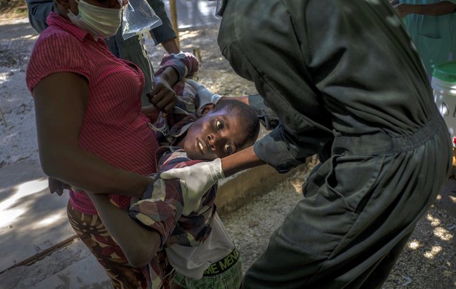 A youth suffering cholera symptoms is helped upon arrival at a clinic run by Doctors Without Borders in Port-au-Prince, Haiti, Thursday, October 27, 2022. (Photo by Ramon Espinosa/AP Photo)