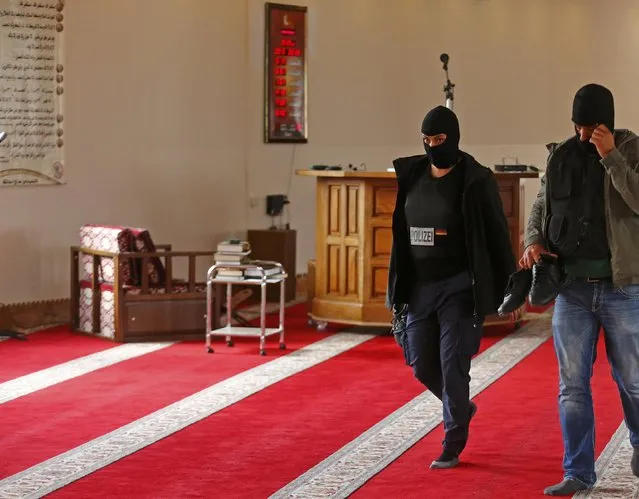 German plain clothes police officers walk inside a mosque in Berlin, Germany September 22, 2015. German police said they raided eight properties in Berlin early on Tuesday that they believe are being used by suspected Islamists supporting fighting in Syria. It was unclear if they had made any arrests in the raids, which included one on a mosque association. (Photo by Hannibal Hanschke/Reuters)