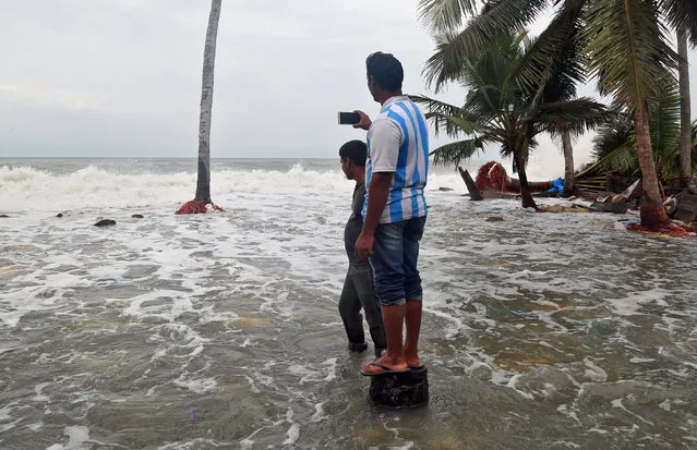 A man uses his mobile phone to take photographs of tides on the shores of the Arabian Sea, after flooding caused by Cyclone Ockhi in the coastal village of Chellanam in the southern state of Kerala, India, December 2, 2017. (Photo by Sivaram V/Reuters)