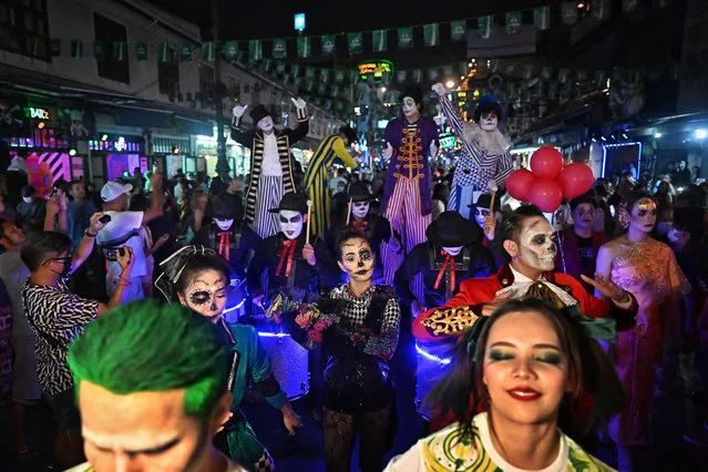 Revelers in costume take part in a parade during Halloween celebrations at popular tourist street Khaosan Road in Bangkok on October 31, 2022. (Photo by Lillian Suwanrumpha/AFP Photo)
