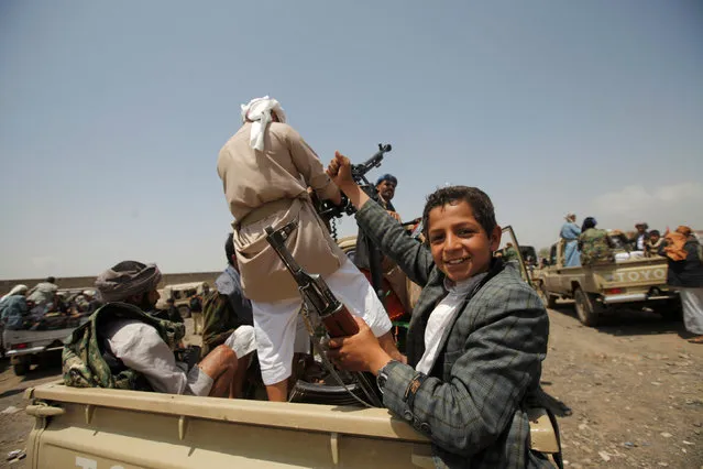 A boy reacts while riding on the back of a truck as they attend a tribal gathering in Yemen's capital Sanaa, August 11, 2016. (Photo by Mohamed al-Sayaghi/Reuters)
