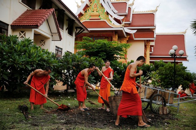 Buddhist monks clean a garden at a temple in Vientiane, Laos September 5, 2016. (Photo by Jorge Silva/Reuters)