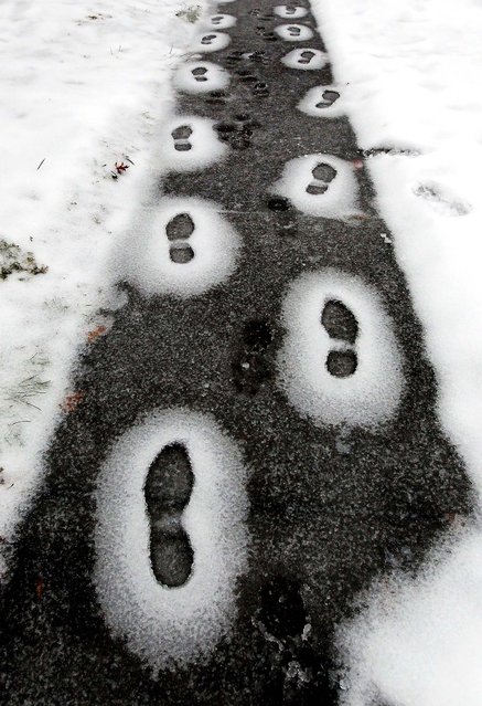 Footprints are frozen in the snow and ice during a freezing rain in Lexington, Kentucky, December 16, 2010. (Photo by Charles Bertram/Lexington Herald-Leader)