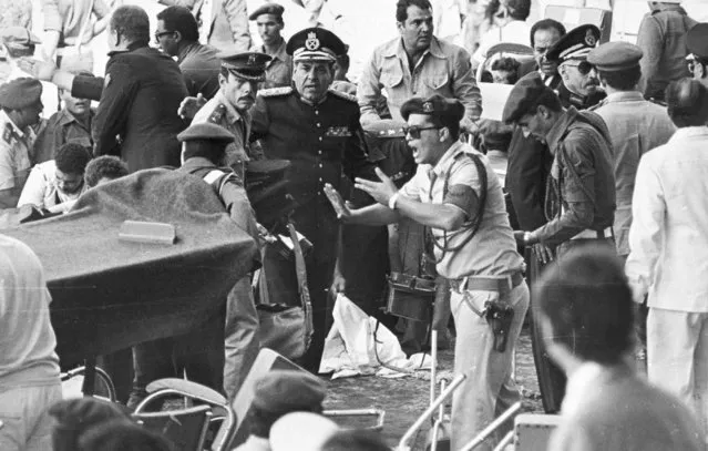 An Egyptian security guard screams at people as medics bring in a stretcher to carry the wounded after the attack which killed President Anwar Sadat, October 6, 1981, as he watched a military parade. (Photo by AP Photo)