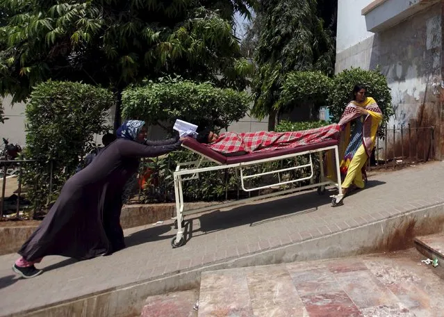 Women wheel a patient on a hospital bed during a strike called by paramedics demanding for health allowance, at the Jinnah Postgraduate Medical Centre (JPMC) in Karachi, Pakistan, September 17, 2015. (Photo by Akhtar Soomro/Reuters)