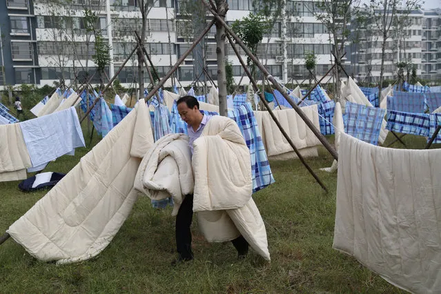 A parent airs quilts for his child at a university campus at the beginning of the new semester in Tai'an, Shandong province, China September 11, 2016. (Photo by Reuters/Stringer)