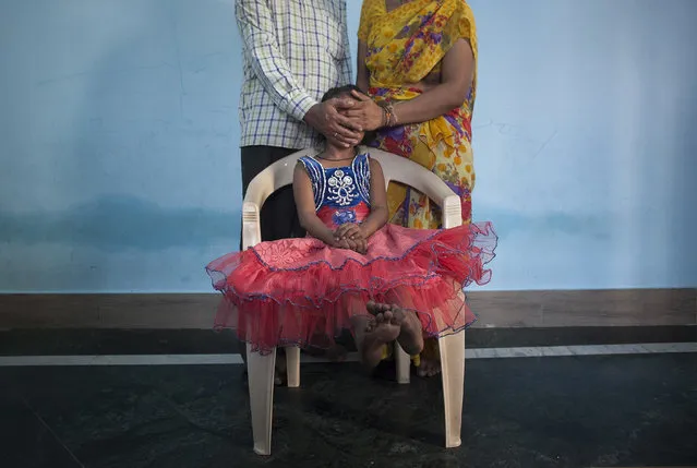 5 year old Nirmala (name changed), who was raped by her mother's boss, poses for a photo with her mother and father on November 12, 2015 in Maharashtra, India. One day Nirmala's mother gave her money to go to the corner store and buy food. While Nirmala was walking the man came up to her and offered to buy her candy. He took her to a wooded area behind an apartment building complex, raped her, and inserted a pen inside her. He left her naked and bleeding heavily. She required two surgeries and stayed in the hospital for three months. They caught the man two weeks later. Since he's been in jail, his family keeps coming to Nirmala's family offering them money to drop the court case. Nirmala's family has since moved to a different neighborhood because the neighbors were gossiping, saying things like “The girl's life is spoiled, what will you do now?”. Nirmala's mother says they won't accept the money offered by the rapist's family, that they want justice instead. (Photo by Getty Images)